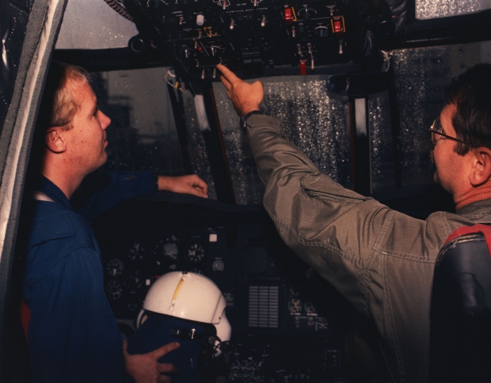 A photograph of Stan Graves (right) teaching Eric Coker something about the D model Chinook helicopter, date unknown.