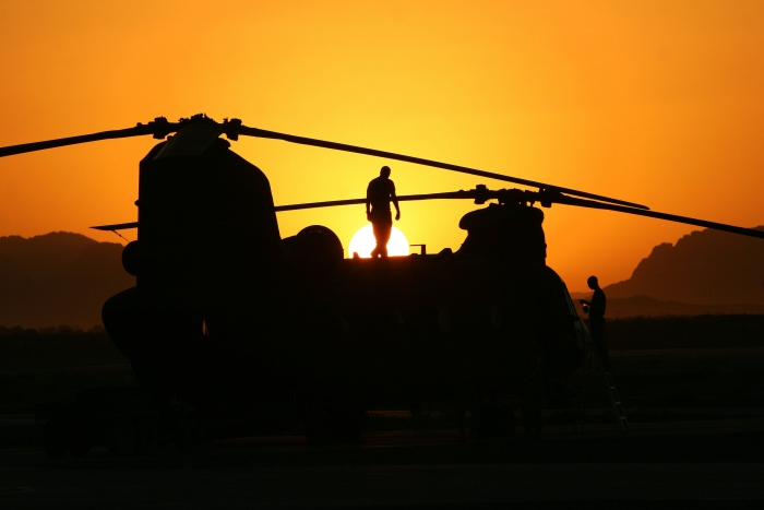 An unknown CH-47 Chinook helicopter at sunset at an unknown location.
