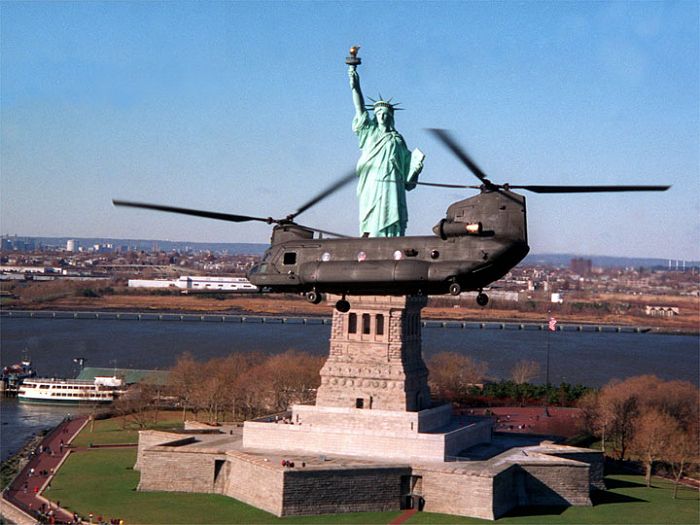 Boeing MH-47E helicopter flying by the Statue of Liberty.