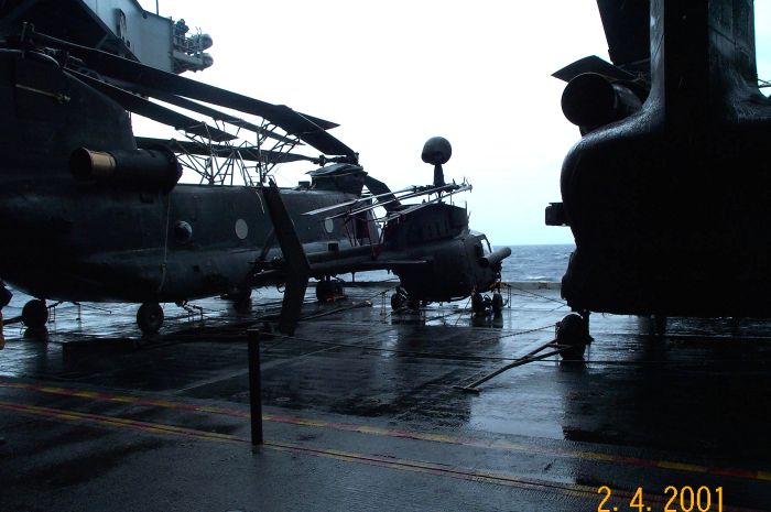 On a ship bound for some distant land, an MH-47 is pictured with the rotor blades folded utilizing a blade folding kit.