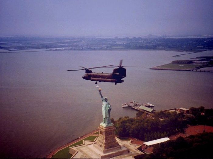 Boeing CH-47D helicopter flying over the Statue of Liberty.