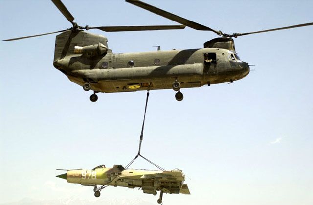 An Afghan MIG-21 wreck is lifted by CH-47D Chinook 86-01649 at Bagram Air Base, Afghanistan, circa 2002.