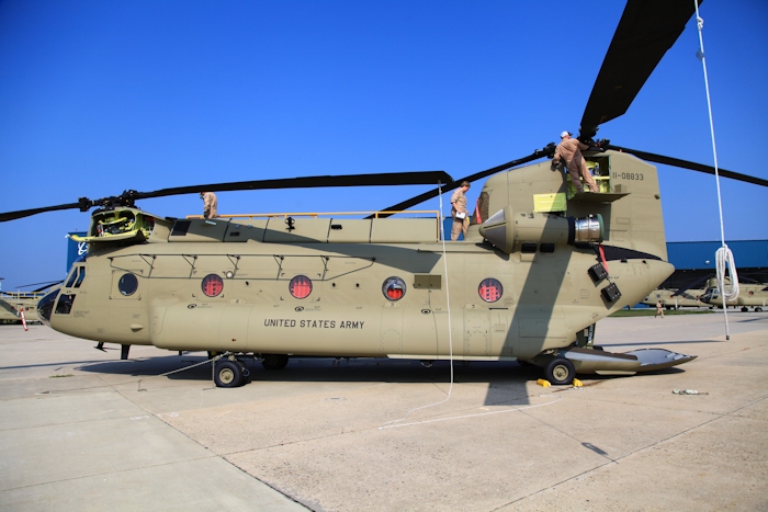 11 September 2013: CH-47F Chinook helicopter 11-08833 undergoes preflight inspection as the crew prepares the aircraft to fly to the Port of Baltimore for transport by ship to the Republic of Korea. Left to right are members of the CH-47F New Equipment Training Team (NETT) - Flight Engineer Mario Sarria, Instructor Pilot Beth McCune, Flight Engineer Wade Cothran. Running around in the background on the right is Standardization Instructor Bill Cagle.