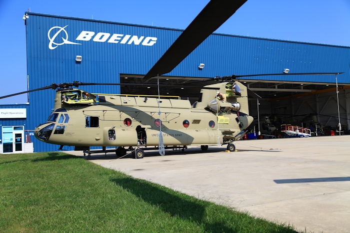 11 September 2013: CH-47F Chinook helicopter 11-08835 rests on the ramp at the Boeing Millville facility, Millville Municipal Airport (KMIV), New Jersey, awaiting movement to the Port of Baltimore for ship transport to the Republic of Korea. New Equipment Training Team (NETT) Maintenance Test Pilot Ken Lynch is preflighting the top while an unknown Boeing employee assists.