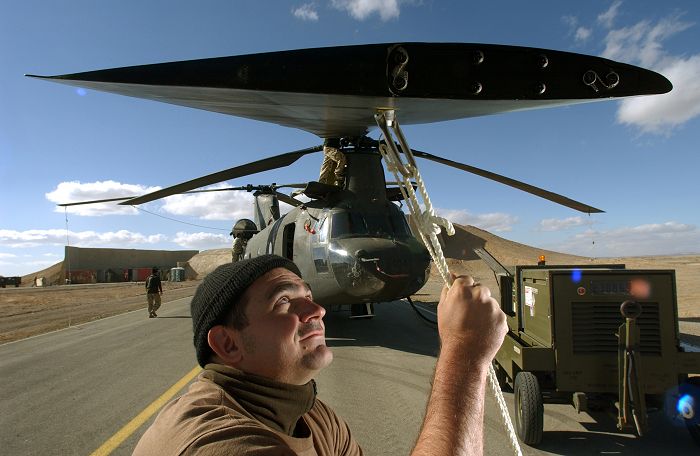 Preparing for the mission, a crewman removes the blades ropes from CH-47D A15-104.