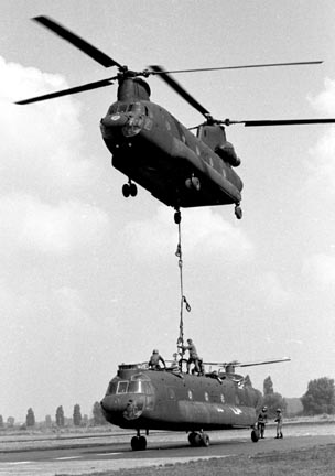Slings secured, an Army CH-47C Chinook helicopter of the 295th Assault Support Helicopter Company, stationed at Coleman Barracks in Mannheim prepares to lift another CH-47C Chinook belonging to the 205th Assault Support Helicopter Company, located at Finthen Army Air Field.
