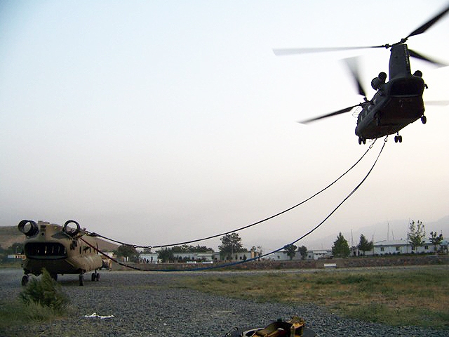 27 July 2010: Camp Blackhorse, Afghanistan  A U.S. Army Chinook helicopter from B Company, Task Force Knighthawk, 3rd Combat Aviation Brigade, TF Falcon, hooks up to a sling a damaged Chinook on Camp Blackhorse.