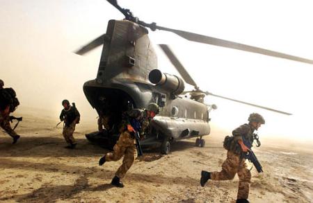 British Royal Marines of 45 Commando scramble out the back of a Chinook helicopter.