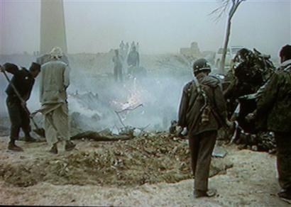 In this image taken from video, Afghans inspect the wreckage of a U.S. military CH-47D Chinook helicopter.