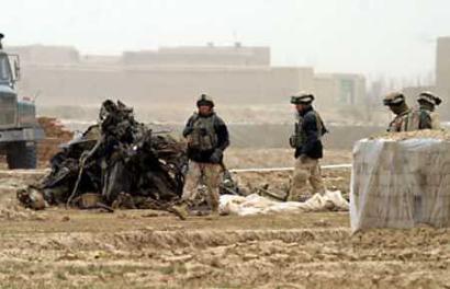 7 April 2005: U.S. troops walk past the wreckage of a U.S. military CH-47D Chinook helicopter that crashed in Ghazni province, southwest of Kabul. The crash killed 18 people a U.S. military spokeswoman said on Thursday.