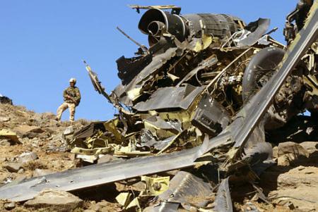 A British Royal Marine Commando stands next to the remains of an U.S. Army MH-47E helicopter.