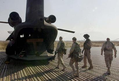 Members of the U.S. Army's 82nd Airborne board a CH-47D Chinook helicopter loaded with Christmas foods.