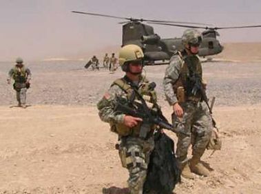 U.S. soldiers, with a Chinook helicopter in the background, return to their base after attending a local tribal council in Zabul province, south of Afghanistan June 30, 2005. The U.S. military was using "all available assets" on Friday to search for a U.S. reconnaissance team that went missing just before a helicopter coming to help them was shot down in eastern Afghanistan, killing all aboard.