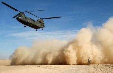 A U.S. CH-47D Chinook helicopter blows up dust as it comes in to land, bringing gifts for distribution to mark Christmas, at the U.S base in Paktika province, south of Kabul, Afghanistan on 24 December 2005.