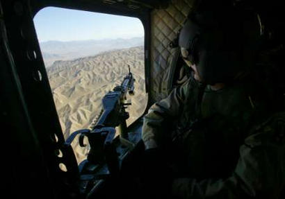 Thursday, 19 February 2004:  A U.S. Army soldier mans the Left Door Gunner position aboard a CH-47D Chinook helicopter while looking down onto a barren Afghan landscape en route to the inauguration ceremony for a Coalition-led Provincial Reconstruction Team (PRT) outpost in Asadabad, about 250 km (155 miles) from Kabul. The PRT program is attempting to assist the central government in extending its authority throughout Afghanistan by establishing regional outposts in areas most in need of increased security and stability.