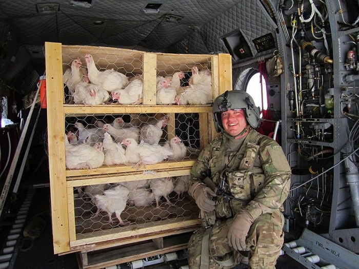 SFC Rob Stephens poses on the ramp of a Sugar Bear aircraft while deployed to Afghanistan in 2011. The load of chickens is interesting to say the least...