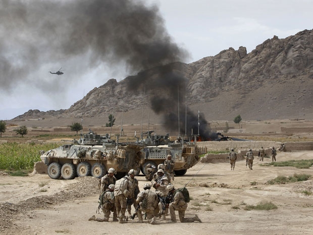 Canadian soldiers gather near a burning Canadian Forces CH147 Chinook helicopter after it made a hard landing close to the village of Bazaar e Panjway, in the Panjway district west of Kandahar on 5 August 2010.