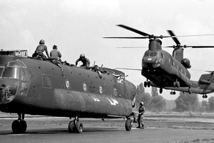 A Chinook hovers nearby preparing to lift another Chinook.