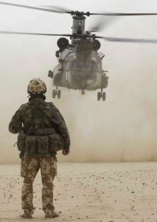 British Radio Signals Operator Corporal Derek Salmon watches an RAF HC Mark II Chinook helicopter.