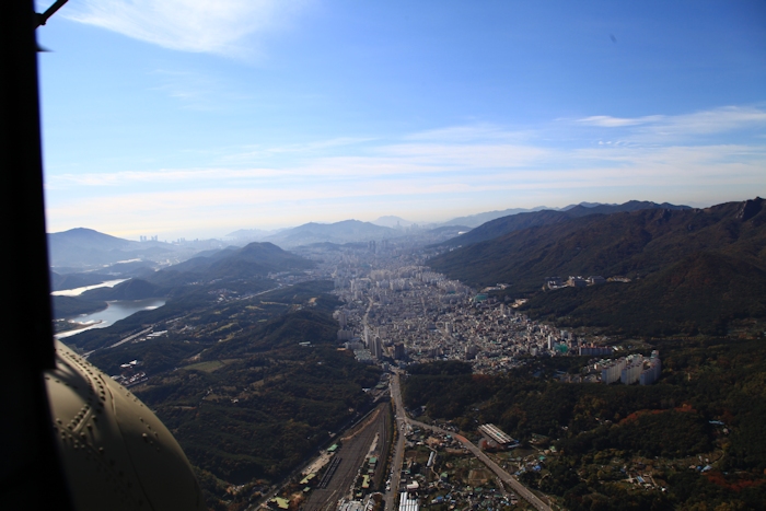 8 November 2013: A look to the south from approximately 10 miles north of the port area of Busan. The valley floors are almost completely covered in concrete from high rise apartments and other city buildings.  The Republic of Korea is a rather small country in terms of land mass so in order to expand and provide space for their citizens the only way for progress is to go vertical with the construction.