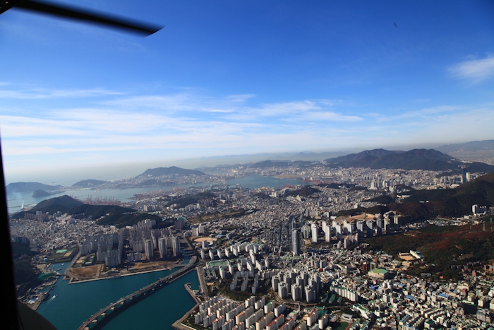 8 November 2013: A look to the southwest at the Busan Port area as the last sortie of CH-47F Chinook helicopters leave the dock enroute to Camp Humphreys. Pier 8 is located to the left of the red cranes near the center of the photograph.