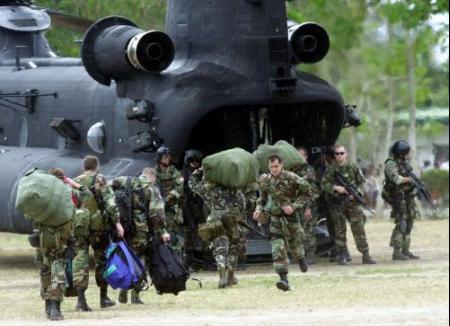 Members of the U.S. Special Forces and their Filipino counterparts board a U.S. Army MH-47E in the Philippines.