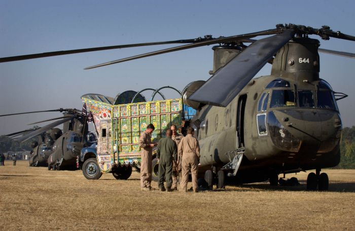 15 November 2005: A local truck carrying Australian stores loads an American CH-47 Chinook helicopter in Islamabad, Pakistan, for a delivery of humanitarian assistance supplies to the earthquake-devastated town of Dhanni in Kashmir.